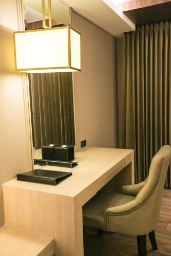 a desk with a lamp and a chair in a room at Arte Hotel - SHA Extra Plus in Bangkok