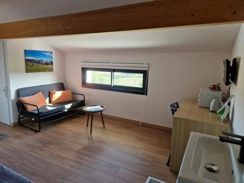 a living room with a couch and a window at Chambre indépendante Pyrenées in Lombez