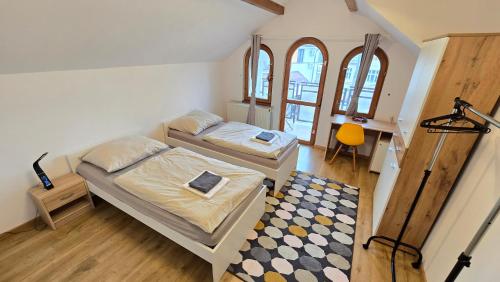 two beds in a small room with a rug at Dom Hlohovec Center in Hlohovec