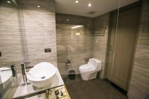 a bathroom with a toilet and a sink at Arte Hotel - SHA Extra Plus in Bangkok