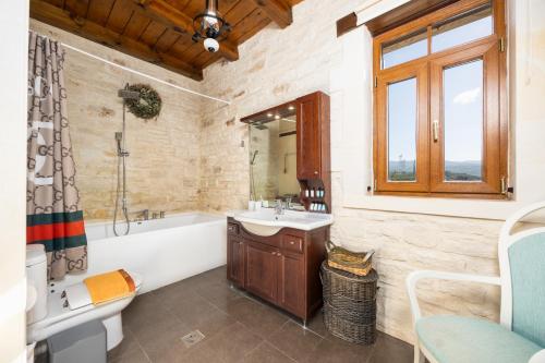a bathroom with a tub and a sink and a bath tub at Villa Marcos Chara in Astérion