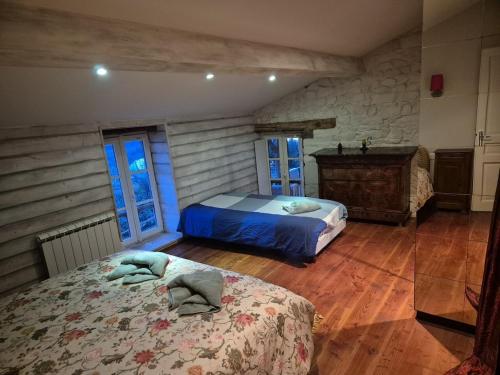 a bedroom with two beds and a wooden floor at Le balcon de Vernay in Vernay