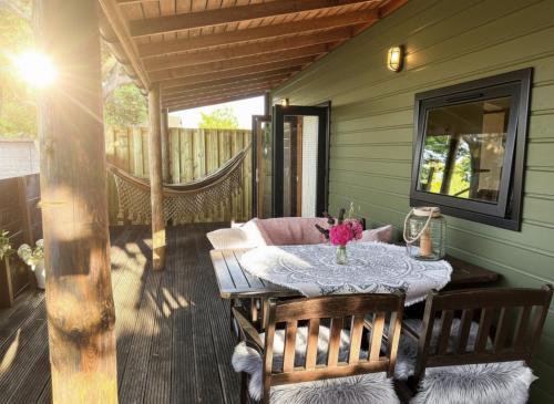 a porch with a table and chairs on a deck at Chalet aan de Rotte in Rotterdam