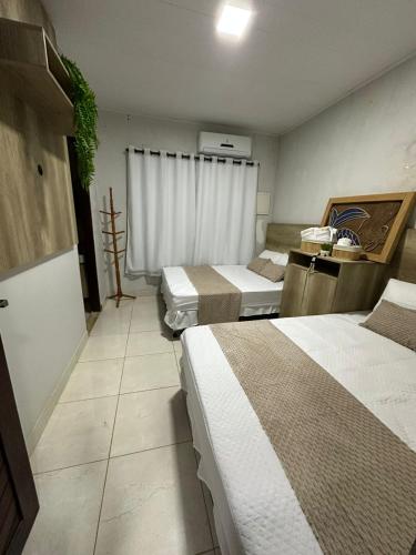 a room with three beds and a window in it at Casa Maresia Ponta da Asa in Coruripe