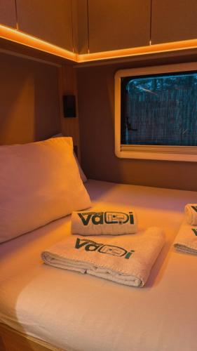 a bed with two towels on top of it at Vadi Karavan Otel in Buca