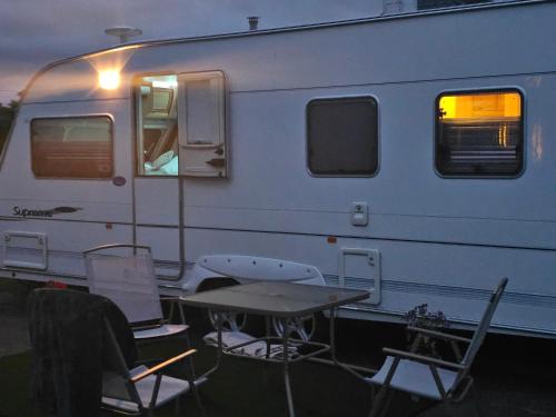 a table and chairs in front of a trailer at Oak House Laois B&B in Portarlington