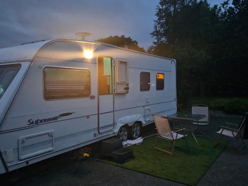 a white rv parked in a yard with a table at Oak House Laois B&B in Portarlington
