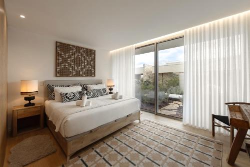 a bedroom with a bed and a large window at Lagoon Residence 56 Deluxe in Óbidos