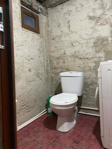 a bathroom with a white toilet in a room at Old Guesthouse Tsikhisdziri in Tsikhisdziri