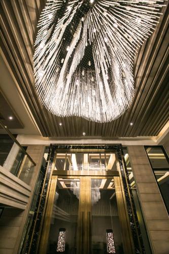 a large chandelier hanging from the ceiling of a building at Arte Hotel - SHA Extra Plus in Bangkok