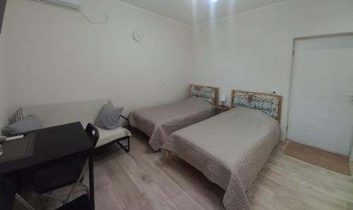 a small room with two beds and a piano at KOD VELIKIH TUJA in Melenci