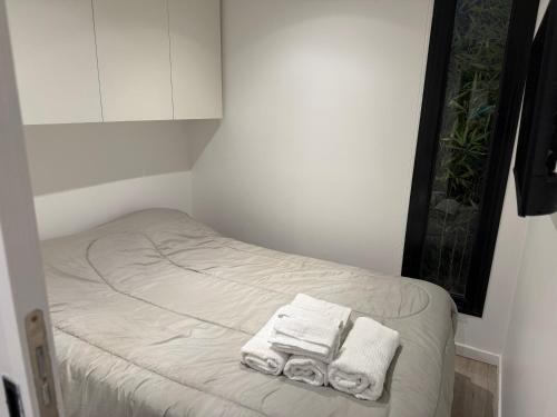 a small room with two towels on a bed at La Posada Bungalows in Necochea