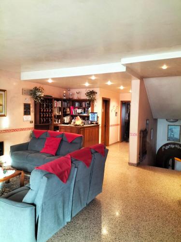 a living room with a blue couch and red pillows at Hotel Monte Fior in Foza