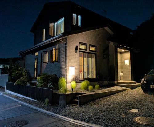 a house at night with a car parked in front at Uchi Matsushima Guesthouse in Matsushima