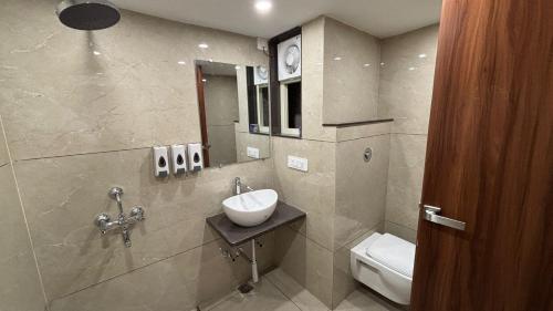 a bathroom with a sink and a toilet at VR Palace in Kānpur