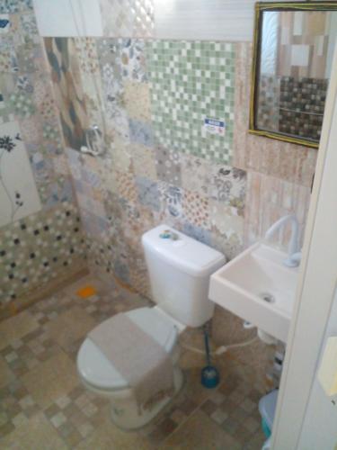 a bathroom with a toilet and a sink at Casa de Temporada de 1 Quarto com Piscina Gruta da Praia 2 in Saquarema