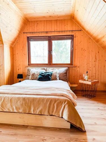 a bedroom with a large bed with a window at Domek u Ewy in Rydzewo
