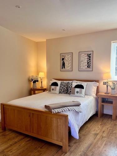 a bedroom with a large bed with two tables and two lamps at The Dove in Knook