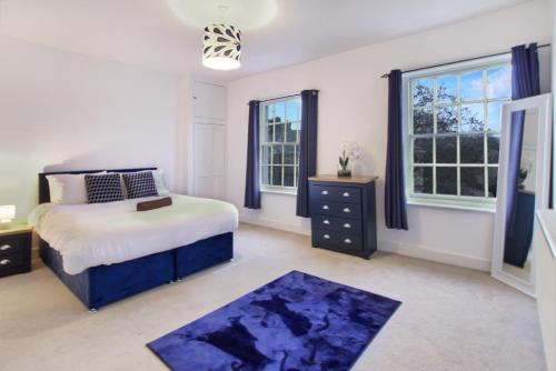 a bedroom with a bed and two windows at town house in Northampton