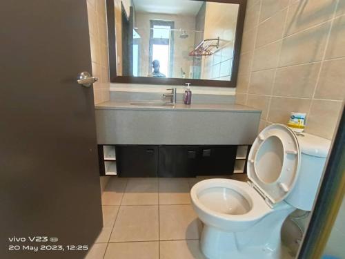a bathroom with a toilet and a sink and a mirror at peacehome 13a in Cyberjaya