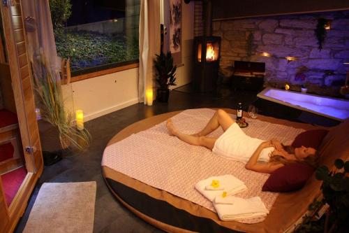 a woman laying on a bed in a room at La Schaumauna, privater Spa in Oberkirch