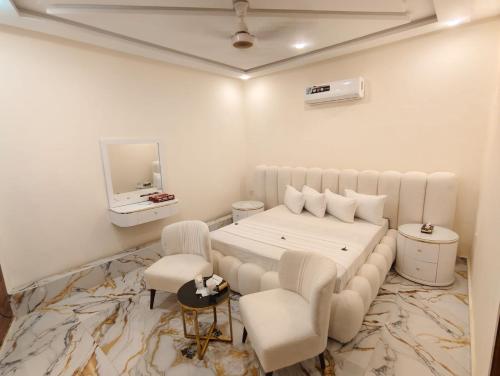 a bedroom with a white bed and a tv at Hotel DE Smart Multan in Multan