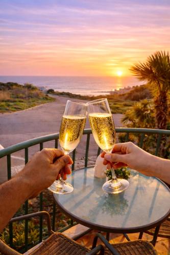 two people holding champagne glasses on a table with the ocean at Casa Da luz 5 - sea view 2 bedrooms apt , beach & swimming-pool in Luz