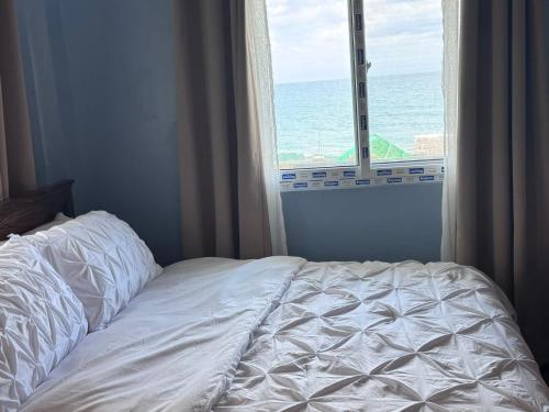 an unmade bed in a bedroom with a window at Brandons Beach Resort in Inayauan