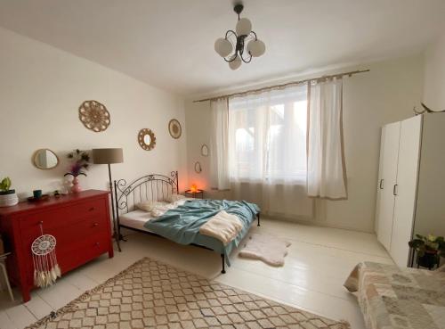 a bedroom with a bed and a dresser and a window at Królewska Sielanka in Mielnik