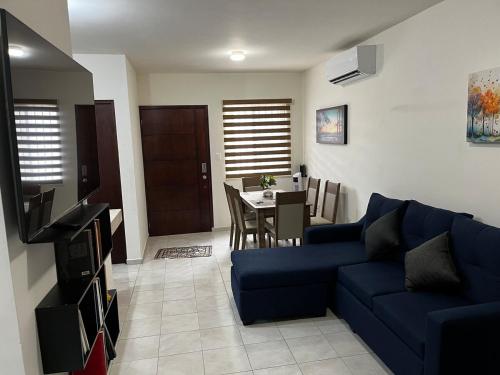 a living room with a blue couch and a table at Departamento Paty in Tampico