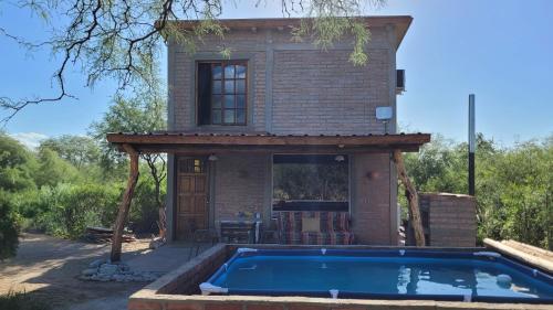 a house with a swimming pool in front of a house at Cabañas Sacha Huasi in Travesía