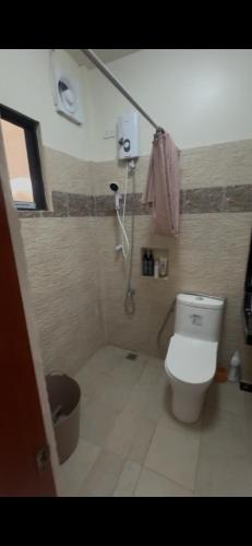 a bathroom with a shower and a toilet in it at Brandons Beach Resort in Inayauan
