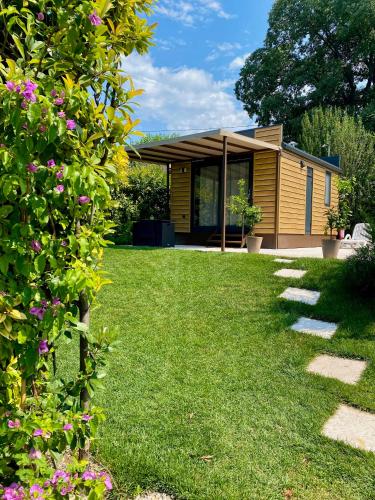 a house in a garden with a lawn at Seregnér Agricamping & Homes - Adults Only 18 in Monzambano