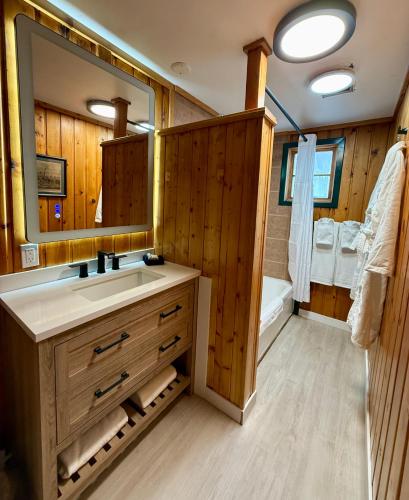a bathroom with a sink and a mirror and a tub at Silver Fork Lodge & Restaurant in Brighton