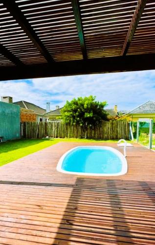 a small swimming pool on a wooden deck at Casa Atantida Sul in Osório