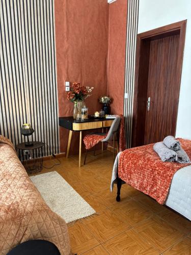 a room with a desk and a bed and a table at Thomas Suite Calheta in Lombada dos Marinheiros