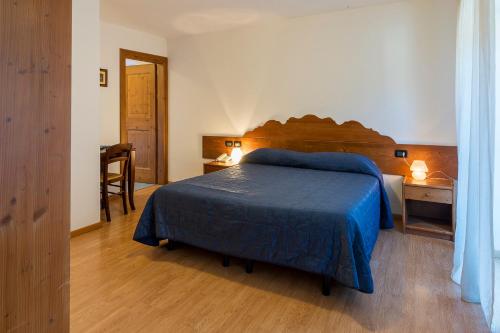 a bedroom with a bed and a desk with a chair at Meublè Blue House in Auronzo di Cadore