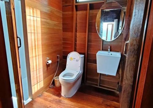 a small bathroom with a toilet and a mirror at Thammachart The Nature in Ban Kai Noi