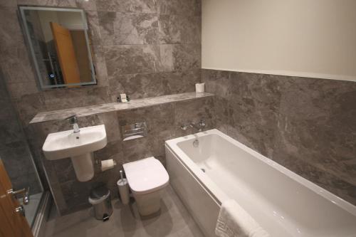 a bathroom with a sink and a tub and a toilet at The Malvern Hills Hotel in Great Malvern
