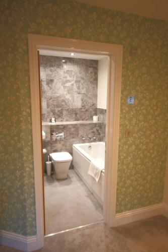 a bathroom with a bath tub and a toilet at The Malvern Hills Hotel in Great Malvern