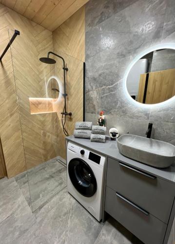 a bathroom with a washing machine and a sink at Marcinówka - Górski Domek w Gorcach in Tylmanowa