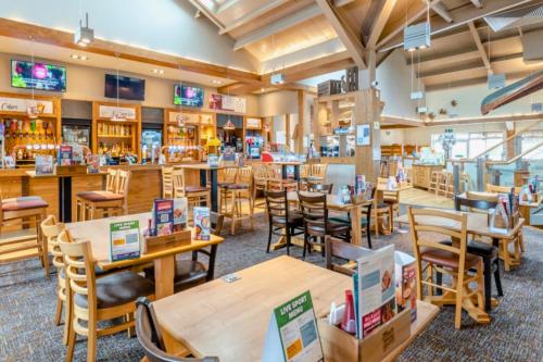 a restaurant with wooden tables and chairs at Meadows 50 - Southview Holiday Park Skegness in Skegness