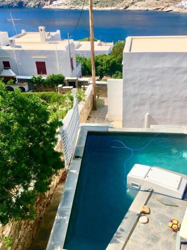 a swimming pool in front of a villa with a view of the water at Villa in Kamares, Sifnos in Kamares