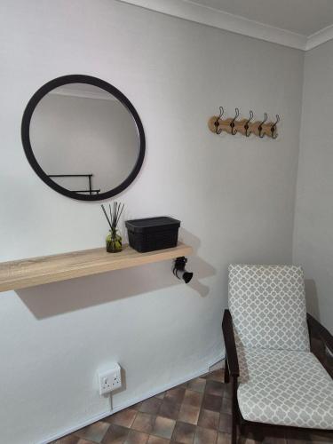 a room with a mirror and a chair on a shelf at @Echeveria in Montagu