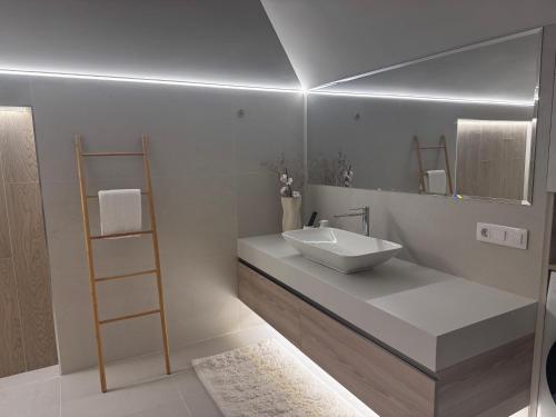 a white bathroom with a sink and a shelf at Boutique apartment Sky Nest in Uman