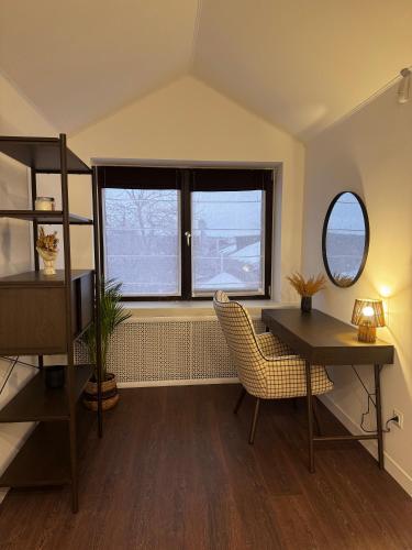 a room with a desk and a table and two windows at Boutique apartment Sky Nest in Uman