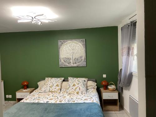 a bedroom with green walls and a bed with pillows at Meuble maison vigneronne in Saint-André-de-Sangonis