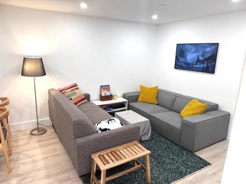 a living room with a couch and a table at The Orange Door Bungalow- 2-BR w private yard, walkable to cafes & restaurants, 10 min to DT in Vancouver