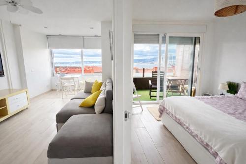 a bedroom with a bed and a living room with a view at Apart CityMar 24h Terraza y vistas Ria Vigo in Vigo