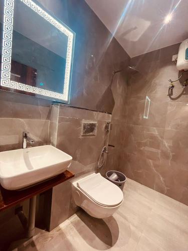 a bathroom with a white toilet and a sink at Ram Anandam inn in Ayodhya